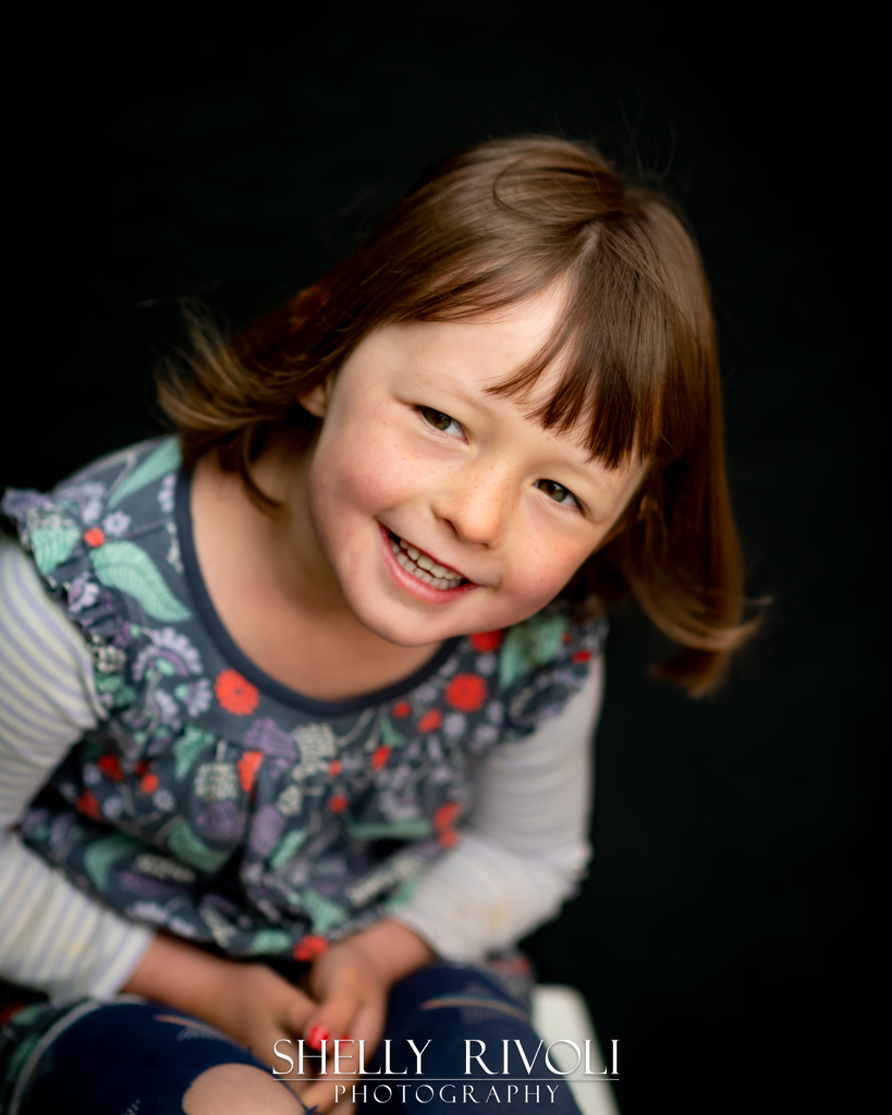 Smiling girl leans in for a portrait with Bay Area photographer Shelly Rivoli