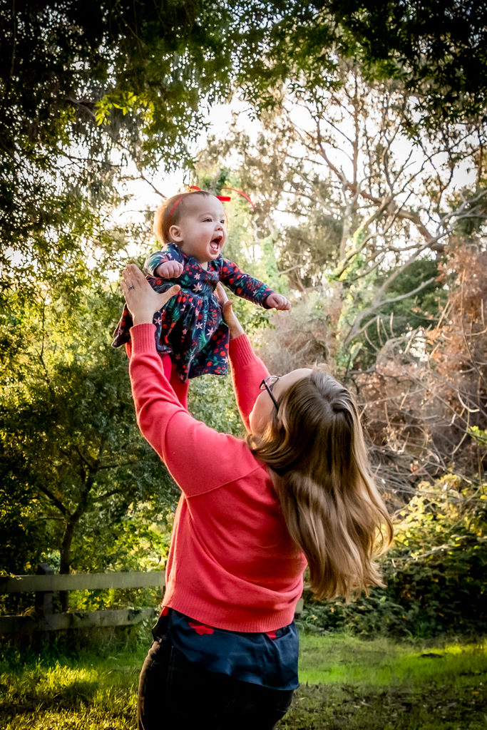Outdoor portrait of mom lifting baby in the air