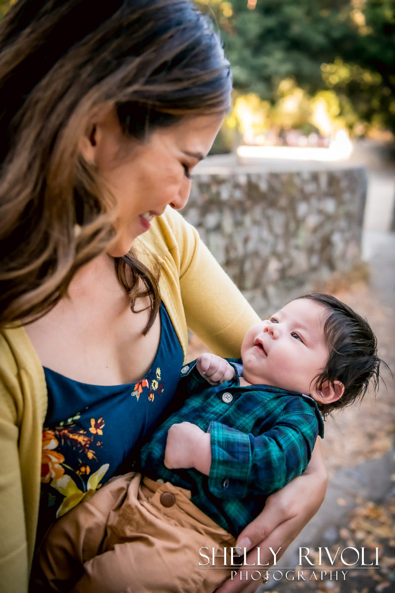 mom with smiling baby during outdoor newborn portrait session