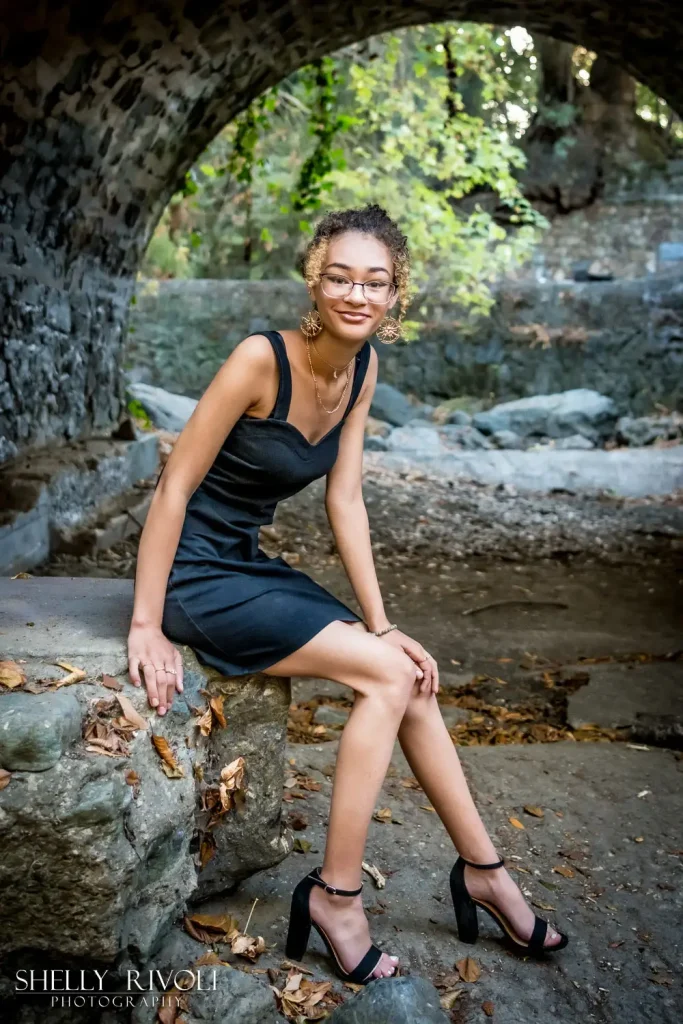 Outdoor senior portrait of young woman in black dress