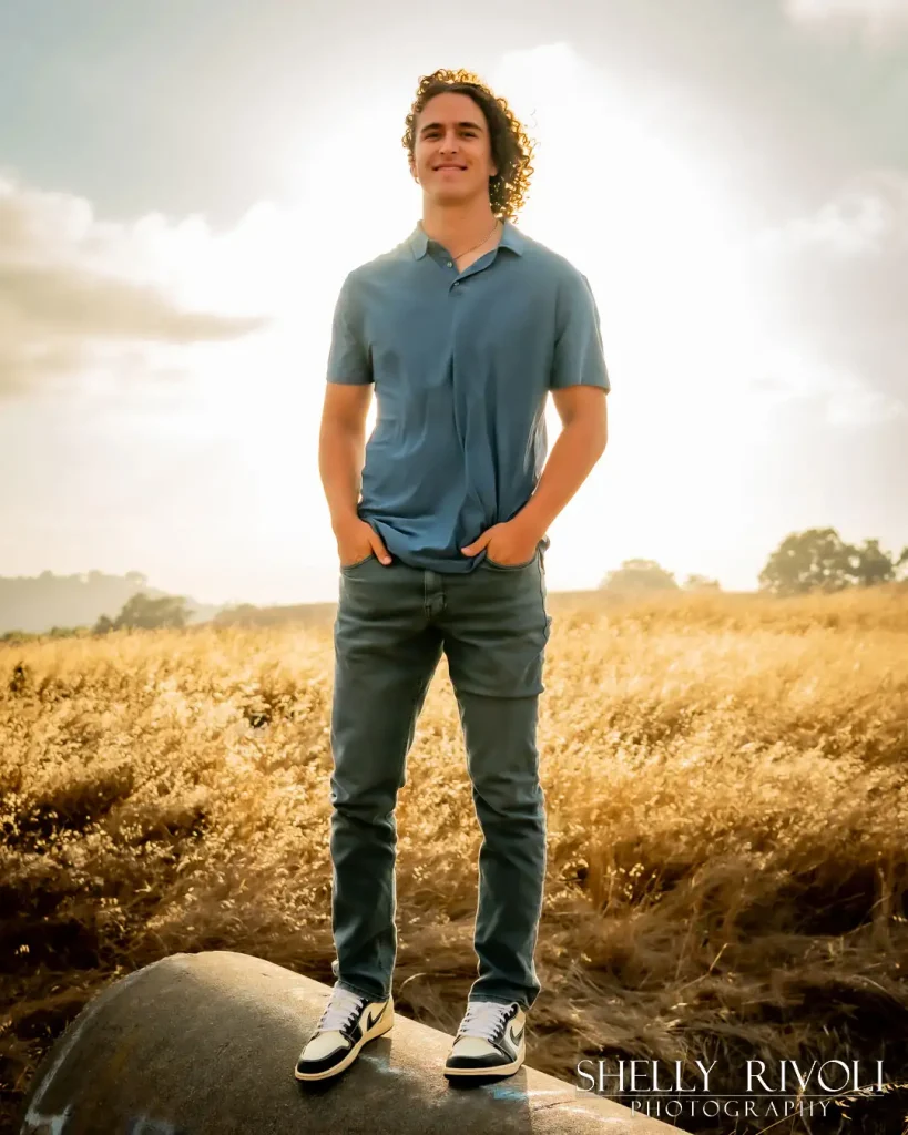 Outdoor senior portrait of young man in golden field in East Bay